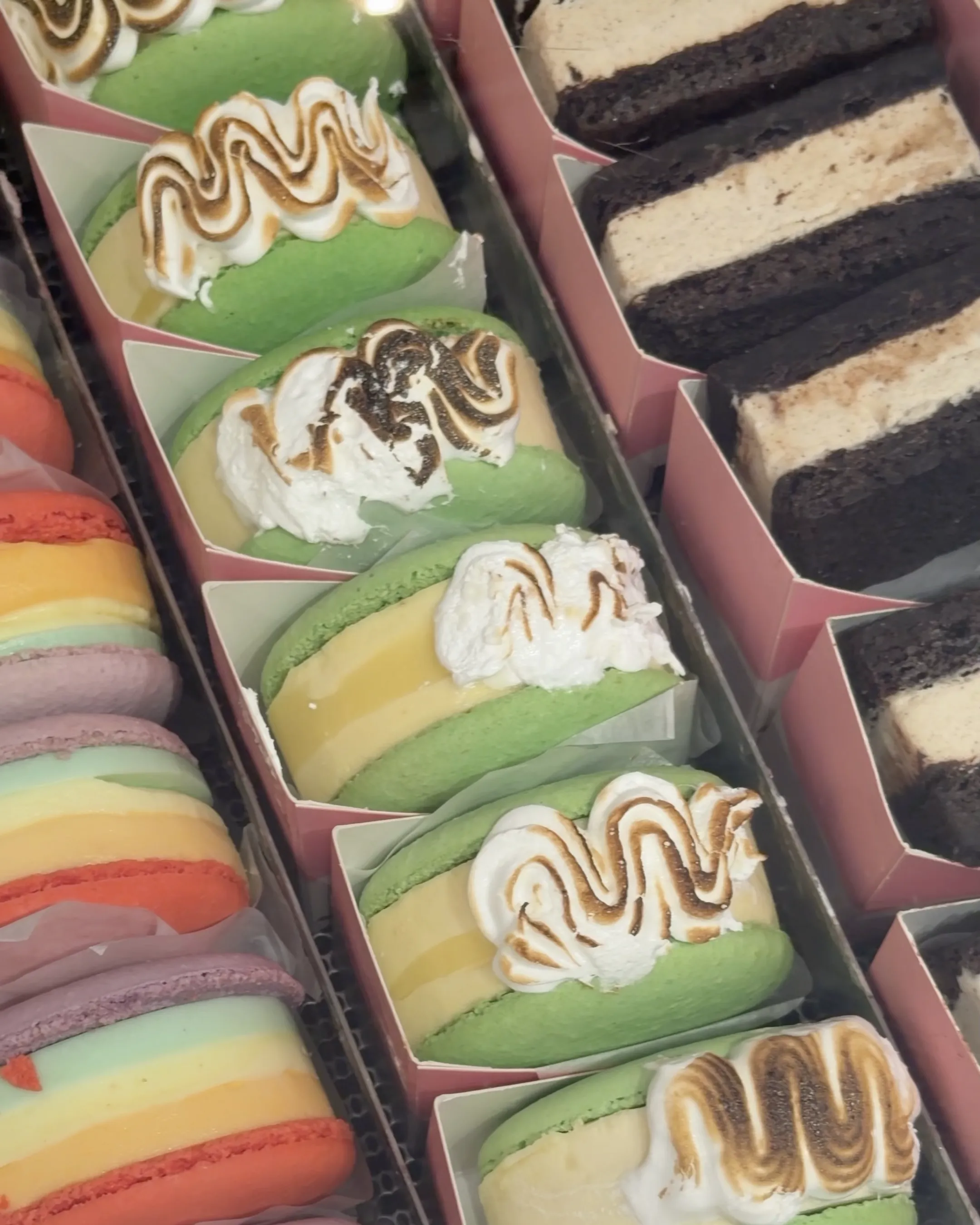 Boxes of colourful macarons topped with toasted meringue
