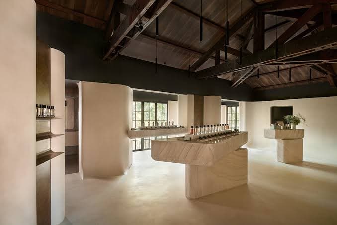 A minimalist fragrance store with a long stone display counter