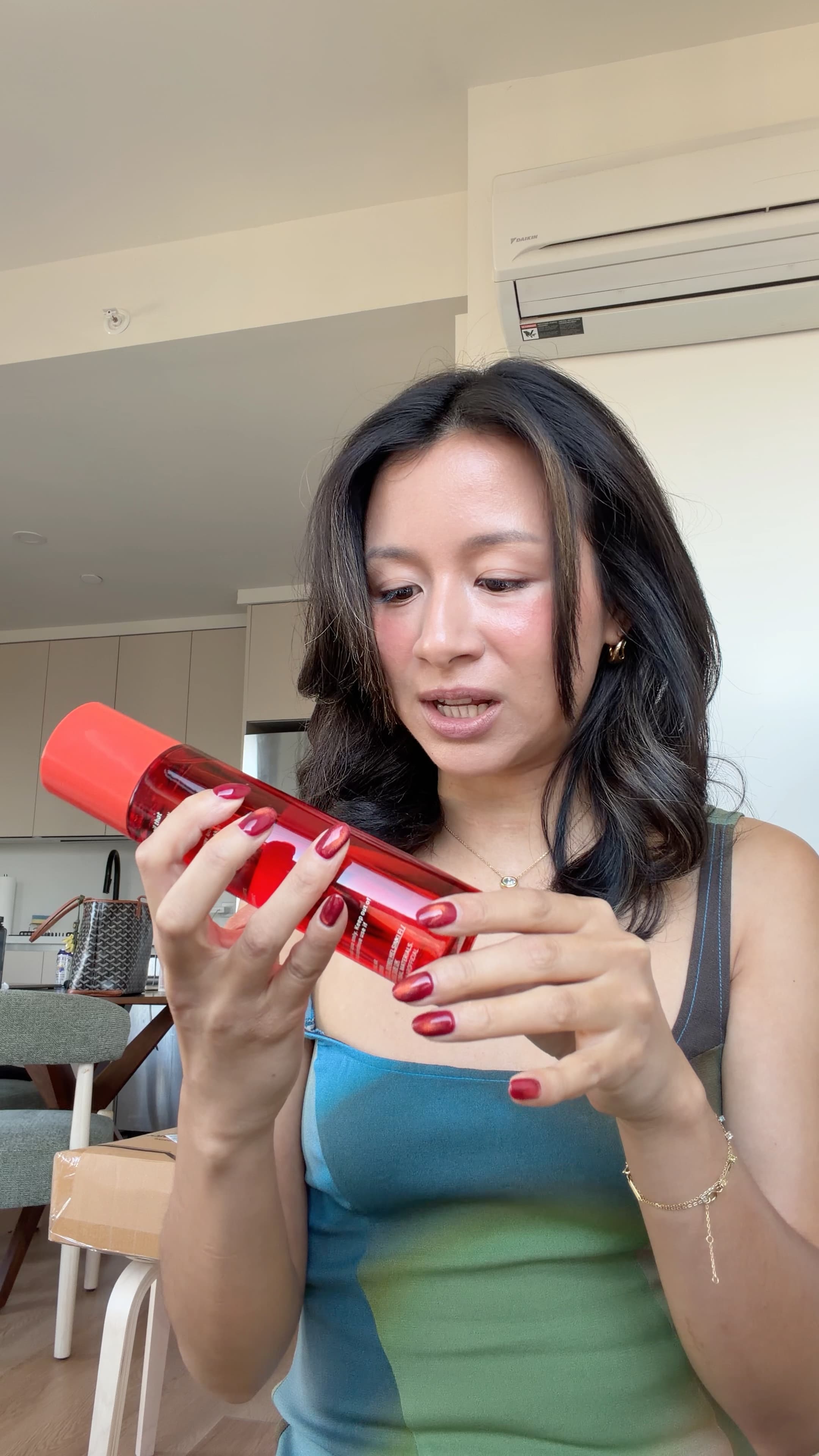 Eileen holding the Cyklar body oil in its red bottle