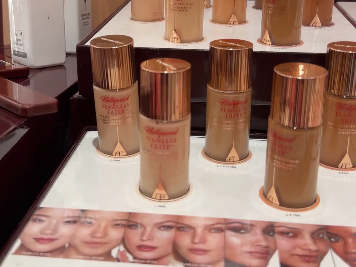 The Hollywood Flawless Filter display in store: rows of gold-topped bottles stepped across a lit counter, each labelled with its shade